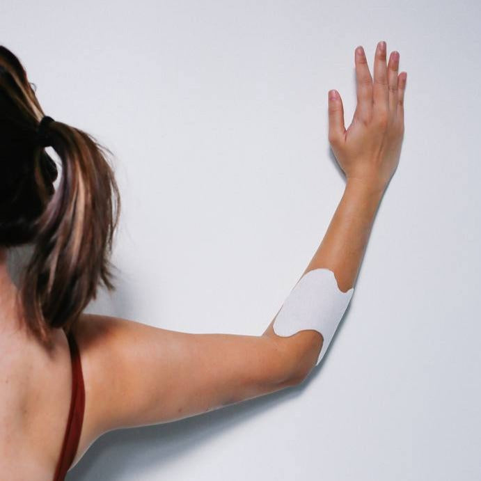 Woman experiencing targeted relief with Activ Labs' Cool Relief Muscle Patch on her arm. Infused with menthol, sodium hyaluronate, glucosamine, and chondroitin, our patches offer effective and convenient relief for joint and muscle pain. Elevate your recovery with our advanced formula