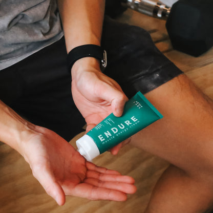 Athlete applying Activ Labs' ENDURE Energy Muscle Cream before a workout. Scientifically formulated with ribose, carnitine, creatine, and caffeine, ENDURE enhances energy levels, reduces muscle fatigue, and promotes faster recovery. Ideal for various activities including running, IPPT, cycling, football, CrossFit, and more. Elevate your performance with ENDURE