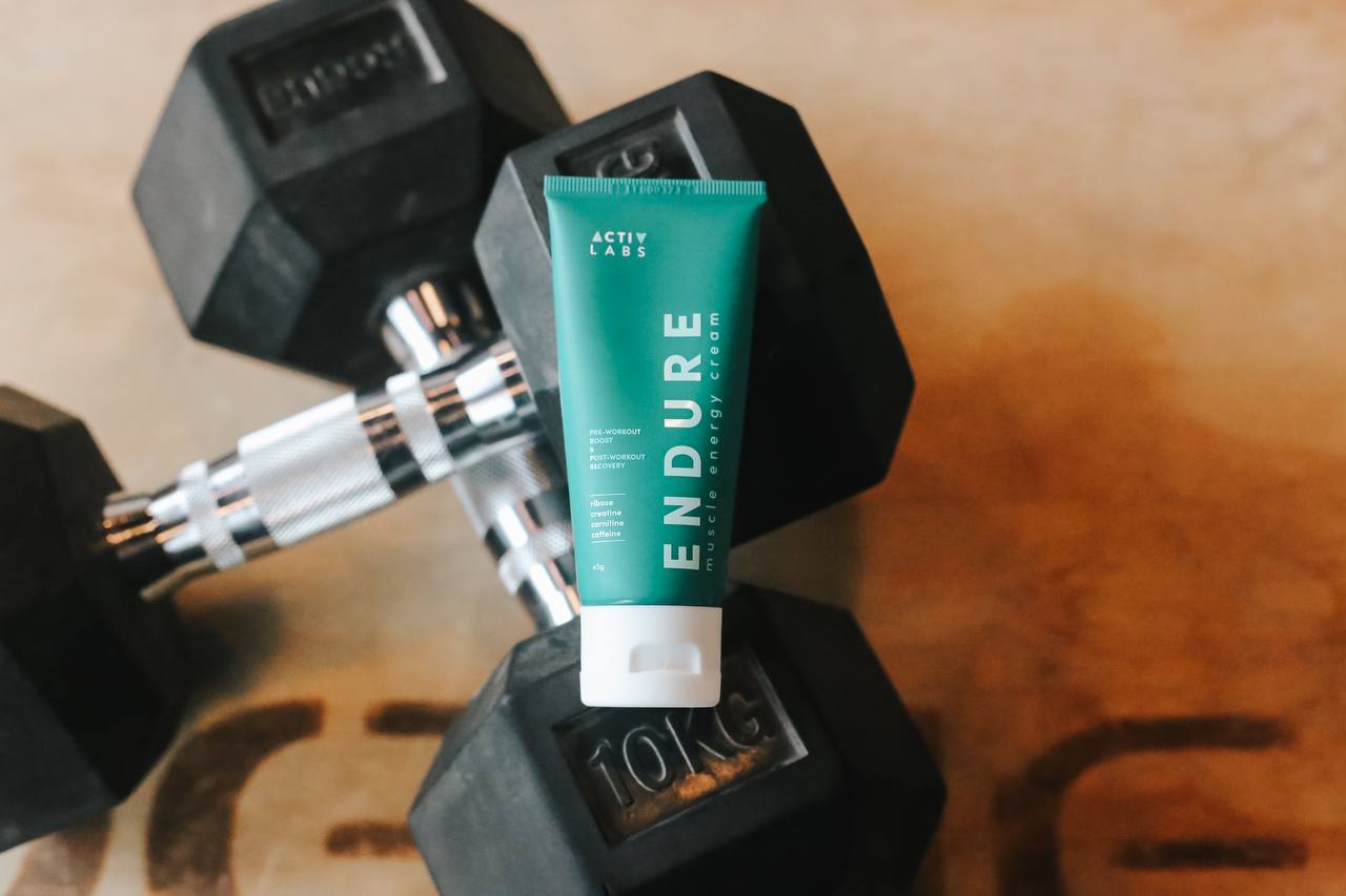 Endure Muscle Energy Cream placed on exercise weights, the perfect companion for athletes seeking enhanced performance, reduced muscle fatigue, and accelerated recovery during intense workouts